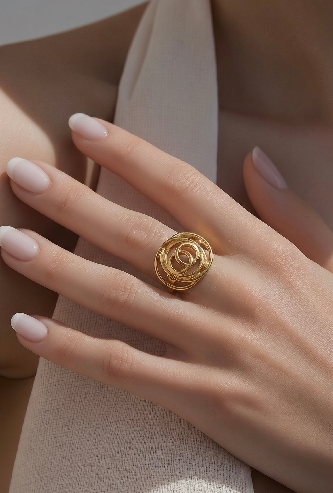 Gold ring on a hand with beige background
