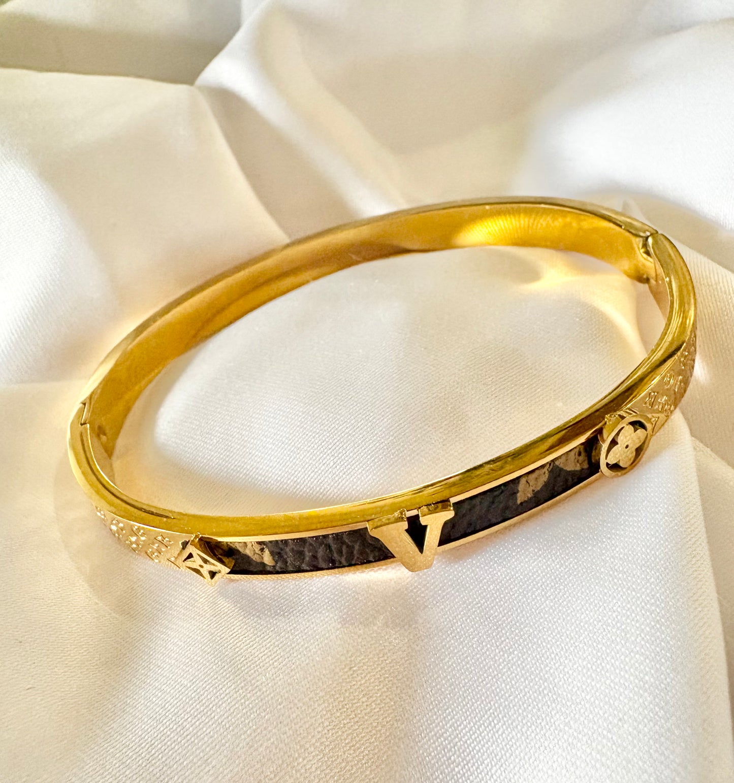 Gold bracelet on a beige fabric background
