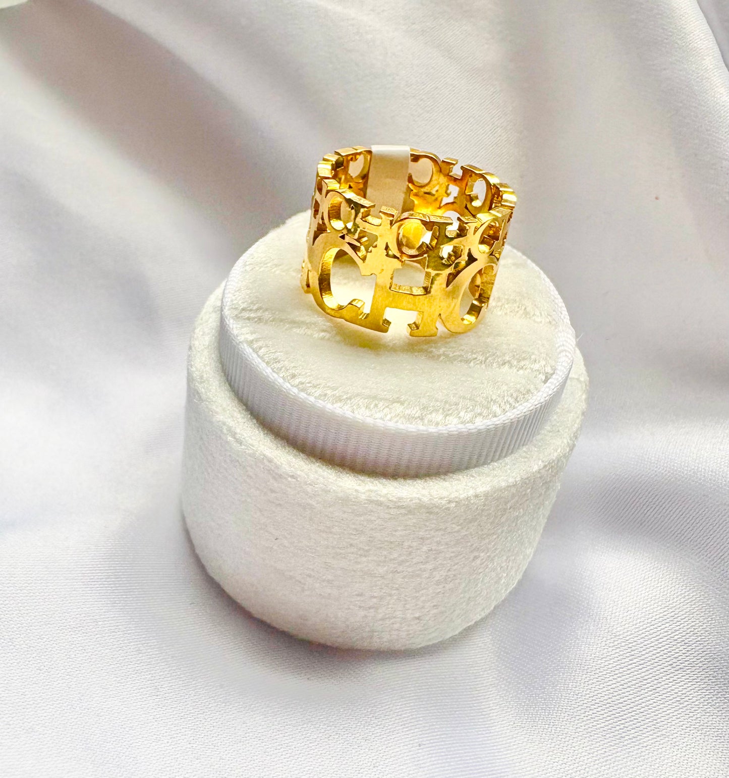 Gold ring on a white cushion with a white background