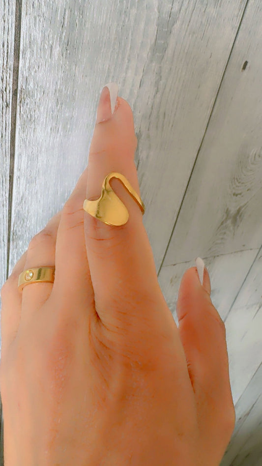 Gold ring on a finger against a wooden background