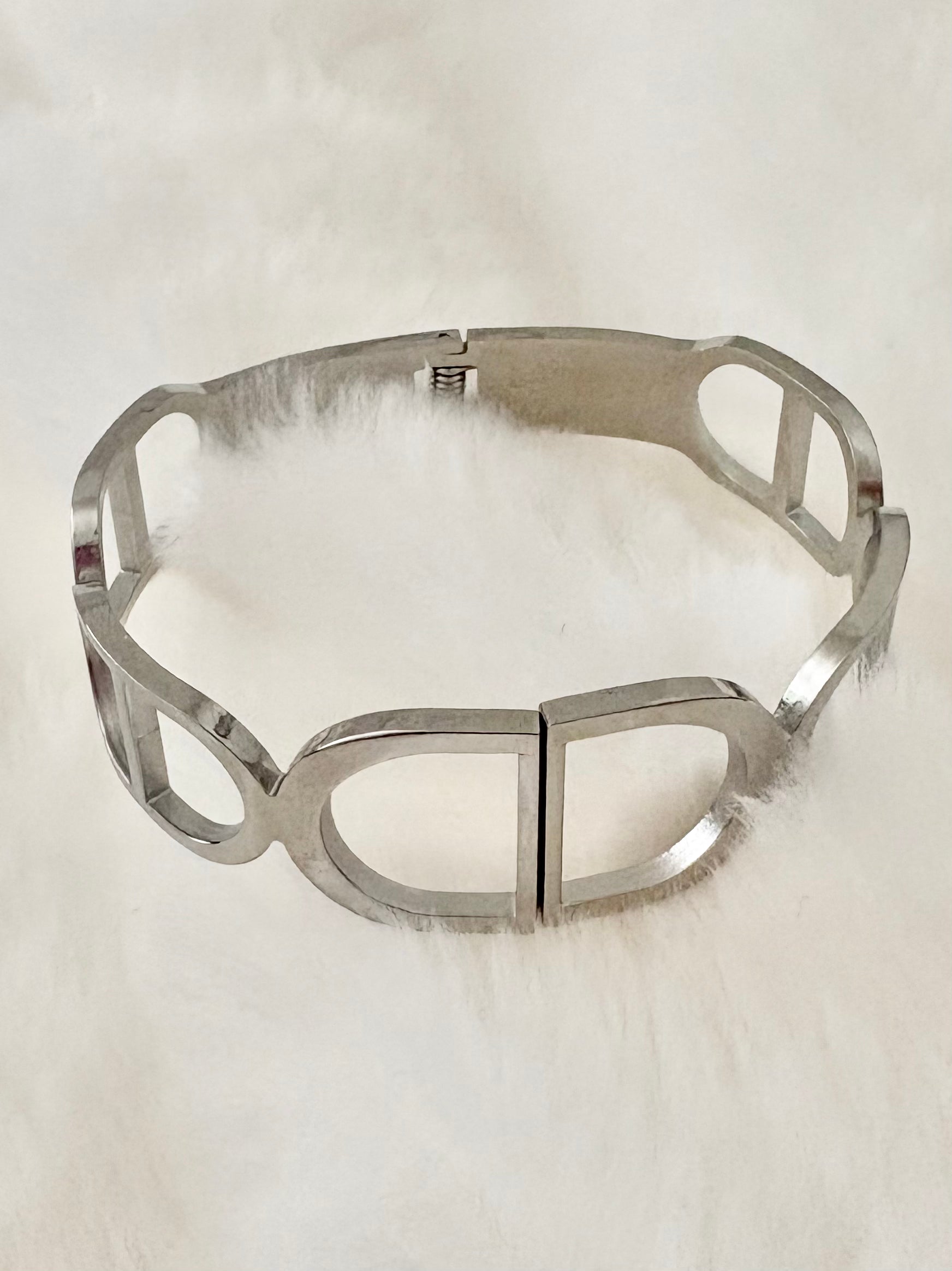 Silver bracelet on a white fur background