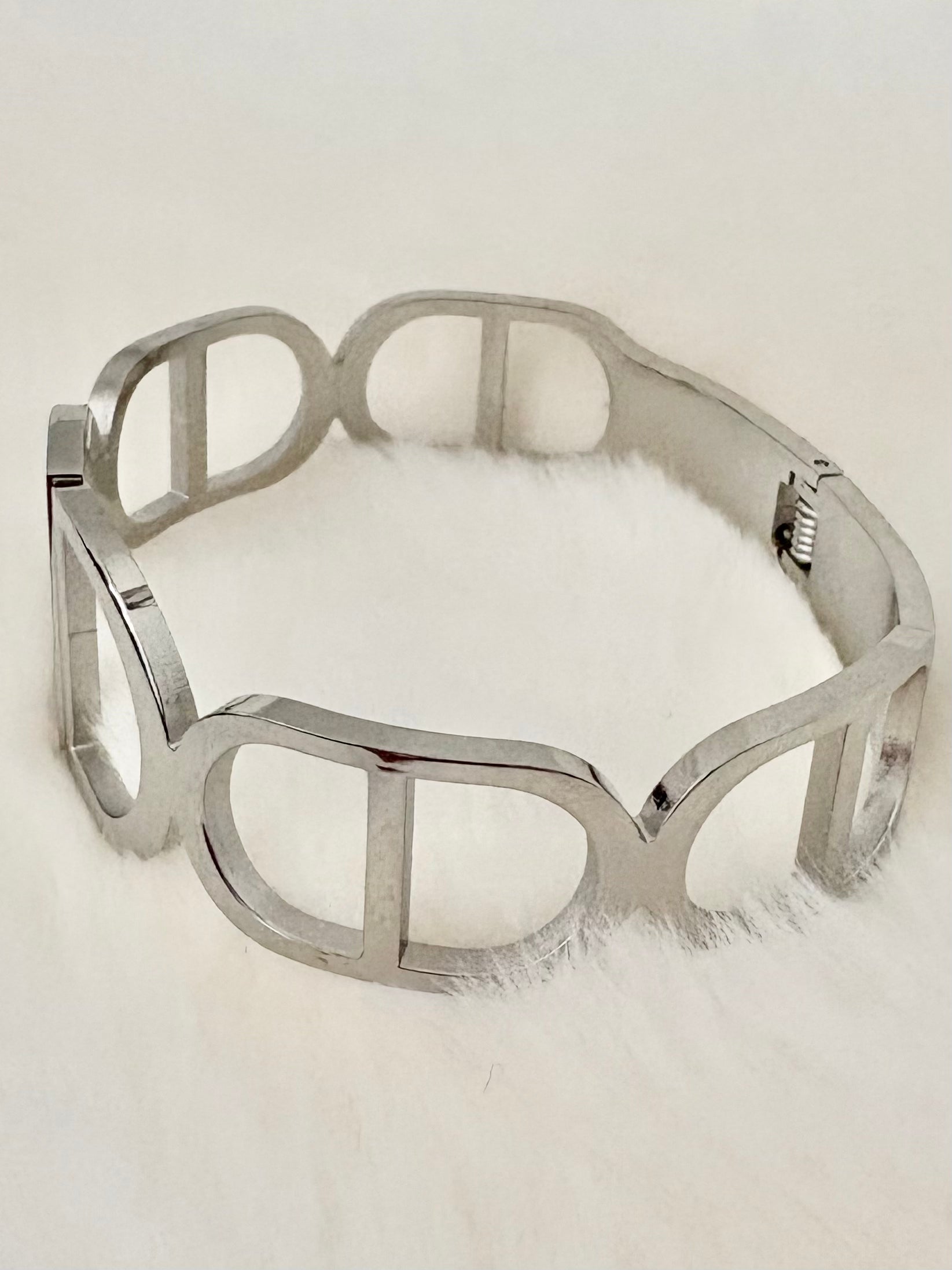 Silver bangle on a white fur surface