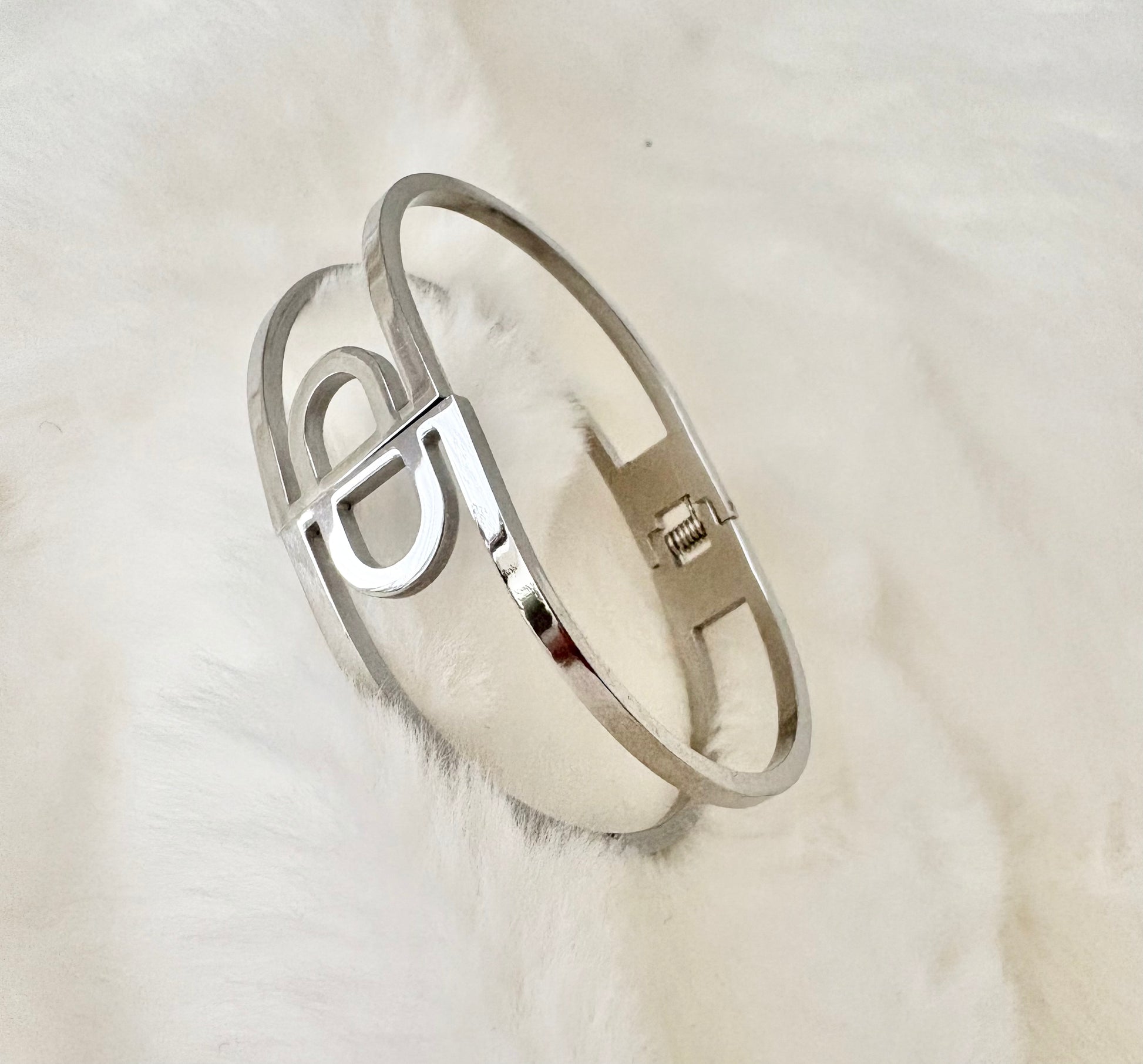 Silver bracelet on a white fur surface