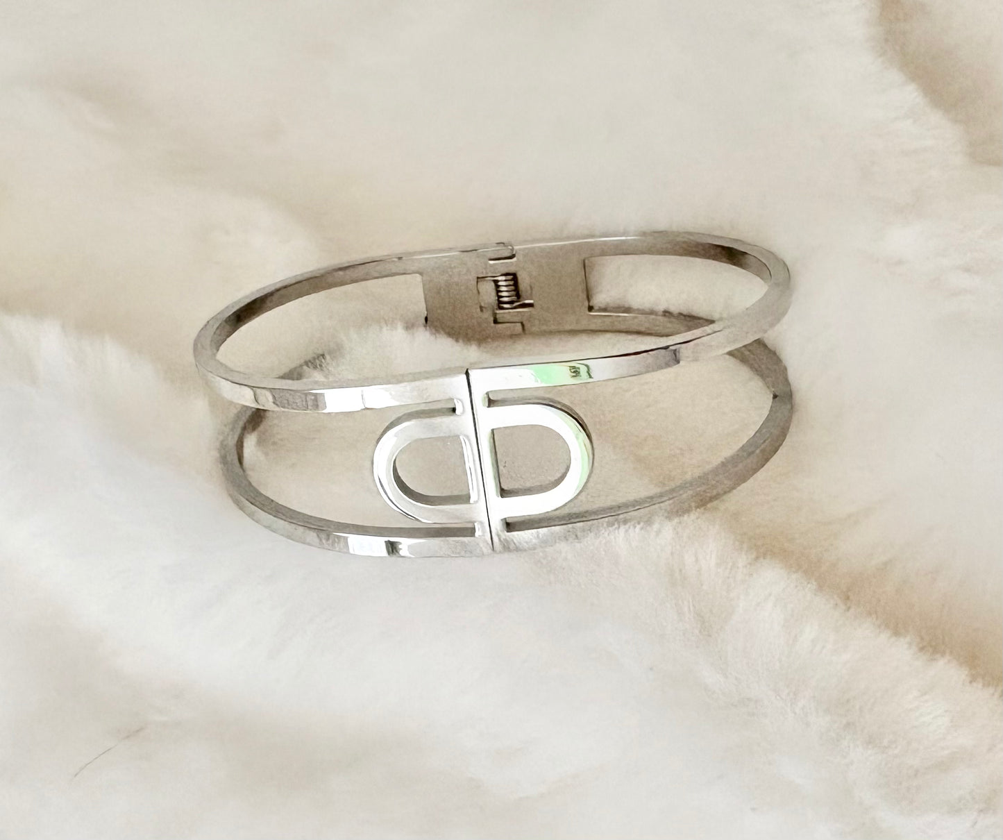 Silver bangle on a white fur background