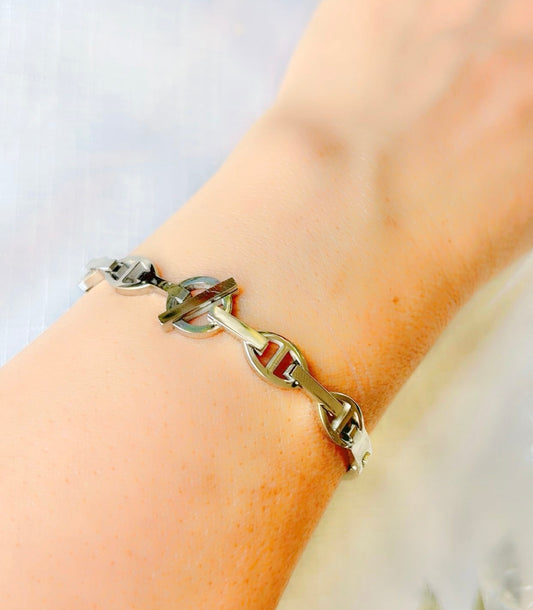 Silver chain bracelet on a wrist with a light background