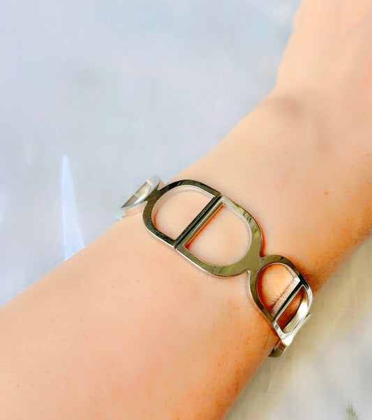Silver bracelet on a wrist with a light background