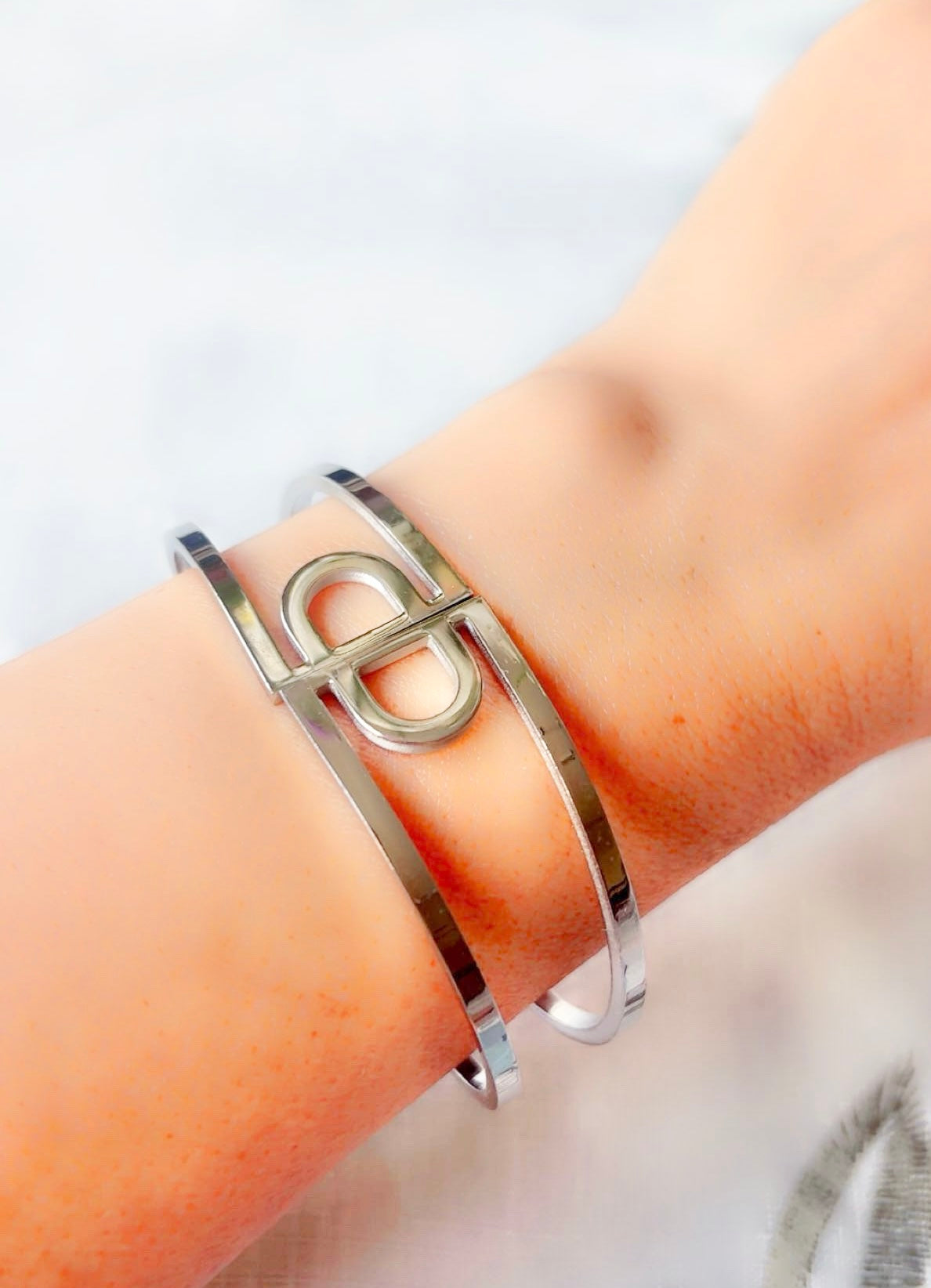 Silver bracelet on a wrist with a light background