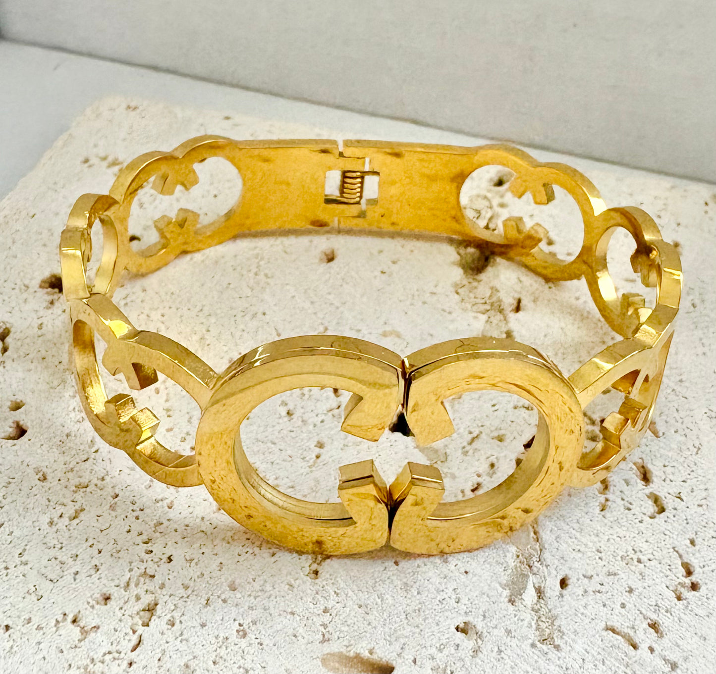 Gold bracelet on a textured beige surface