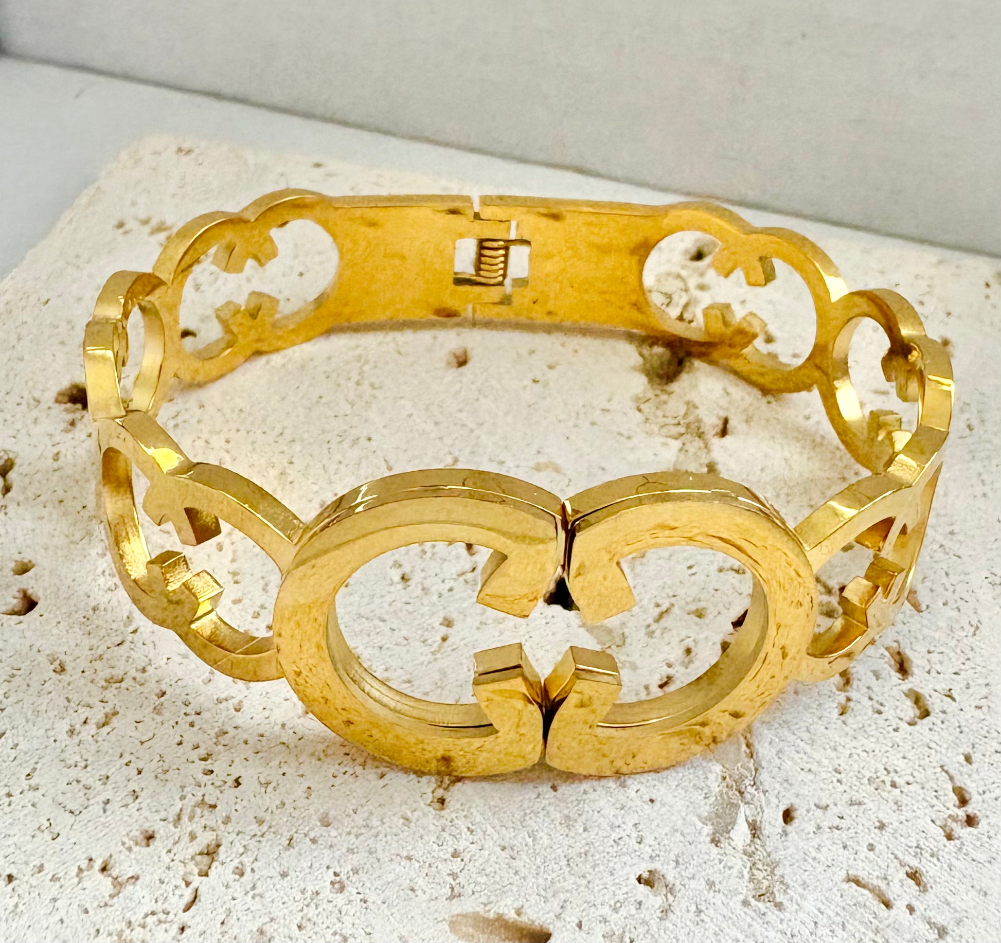 Gold bracelet on a textured beige surface