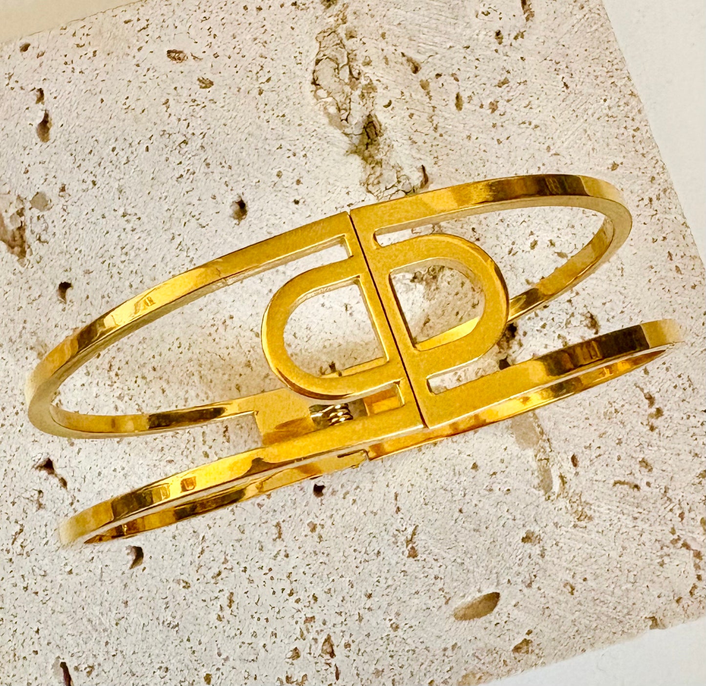 Gold bracelet on a textured stone surface