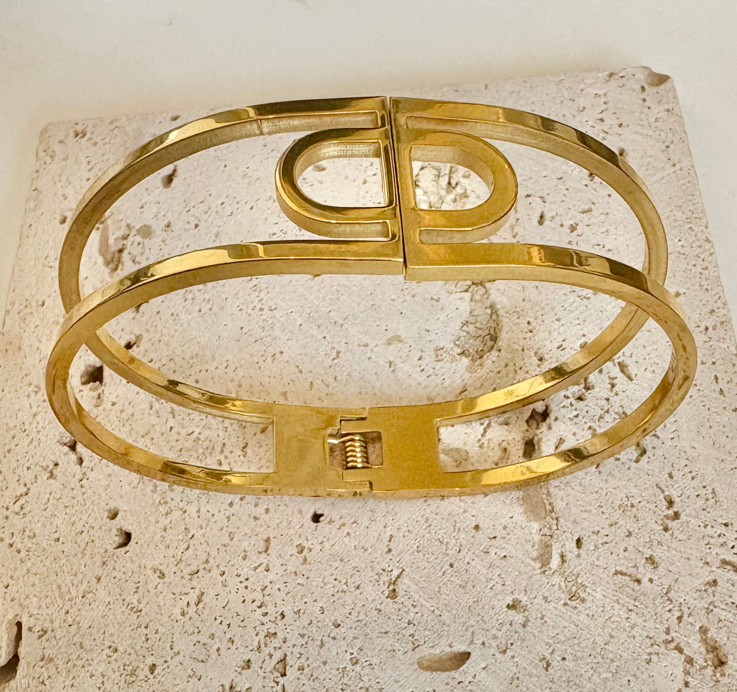 Gold bracelet on a textured stone surface