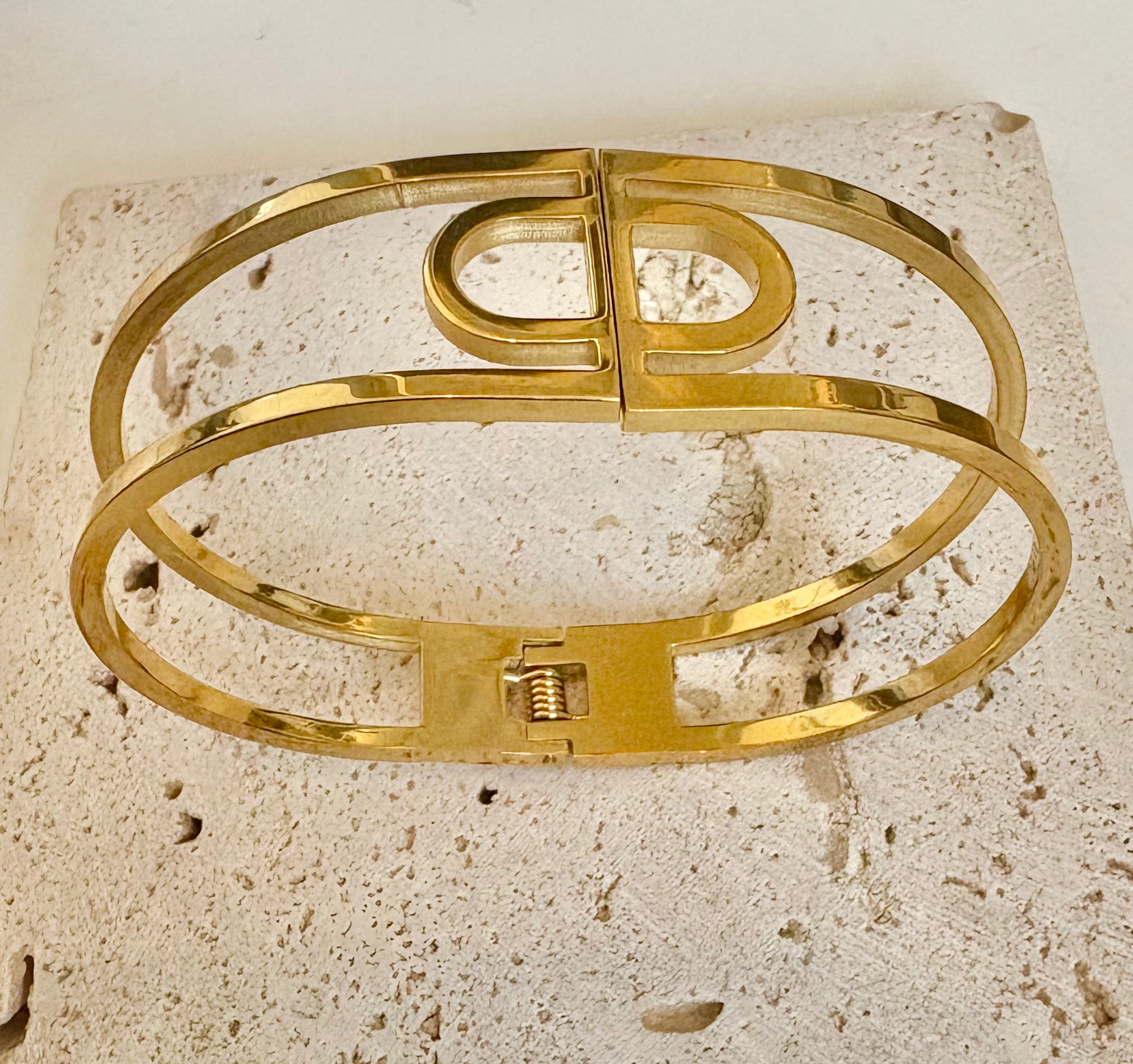 Gold bracelet on a textured stone surface
