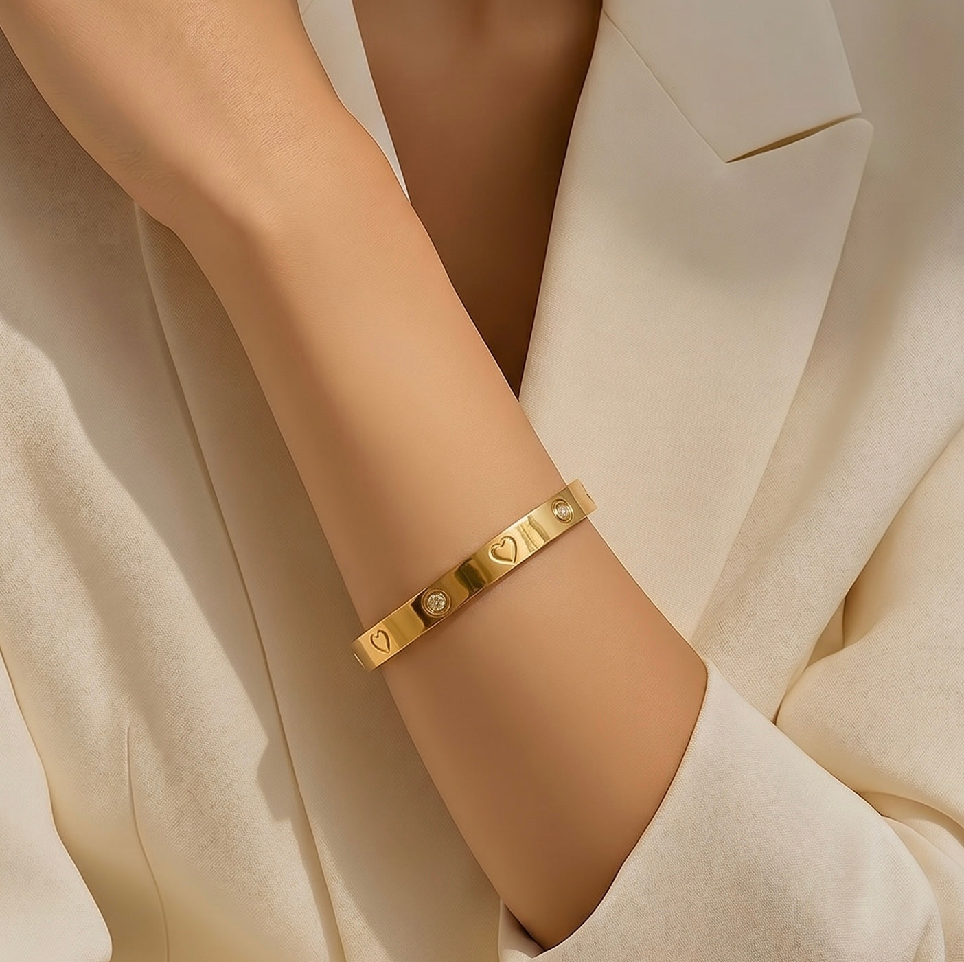 Gold bracelet on a person's wrist with a neutral background