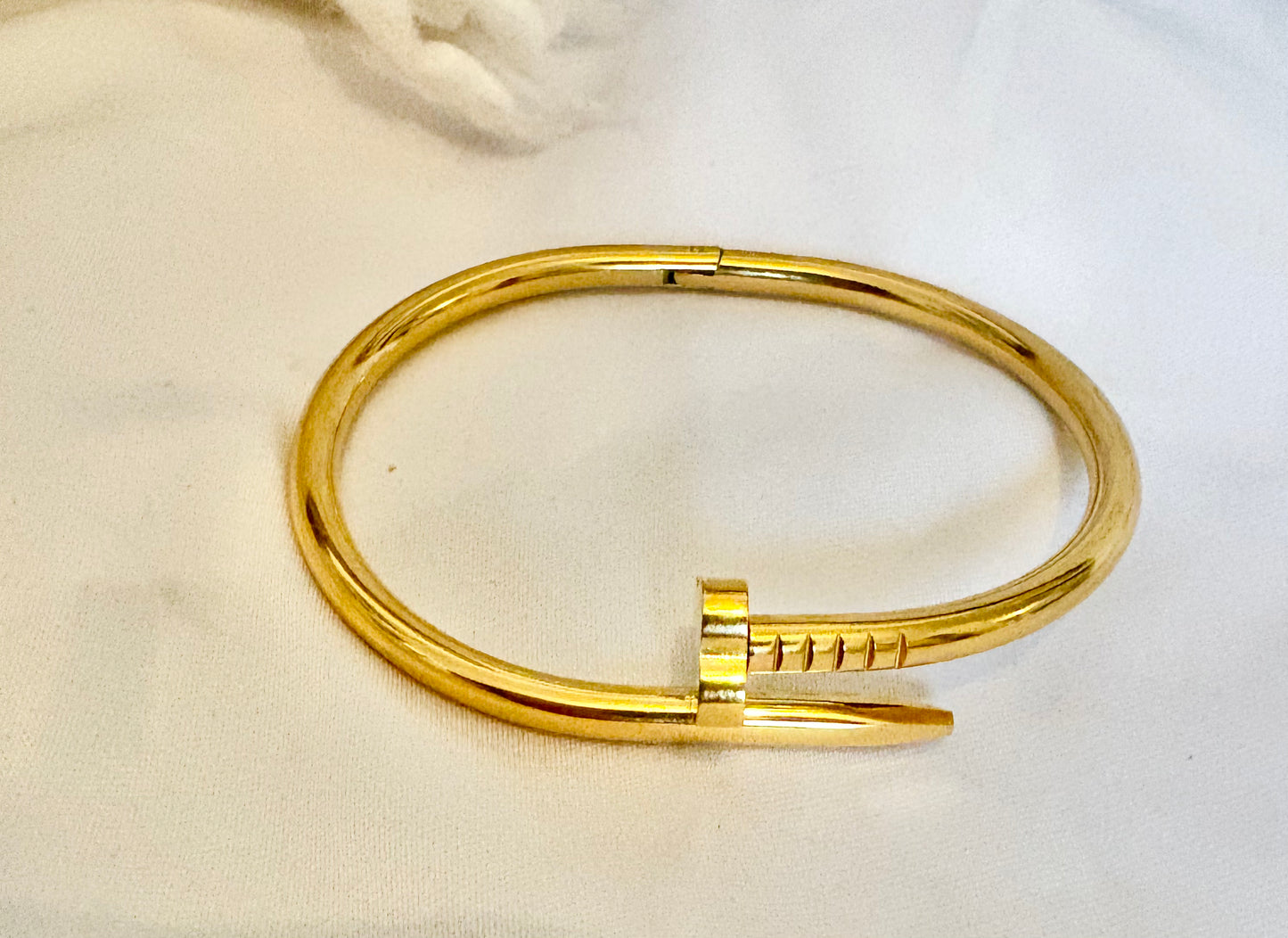 Gold bracelet on a white fabric background