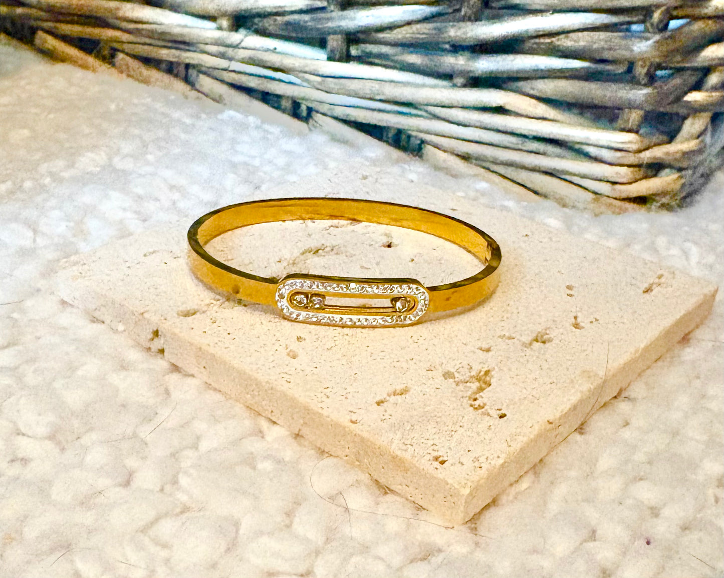 Gold bracelet with a diamond accent on a textured surface