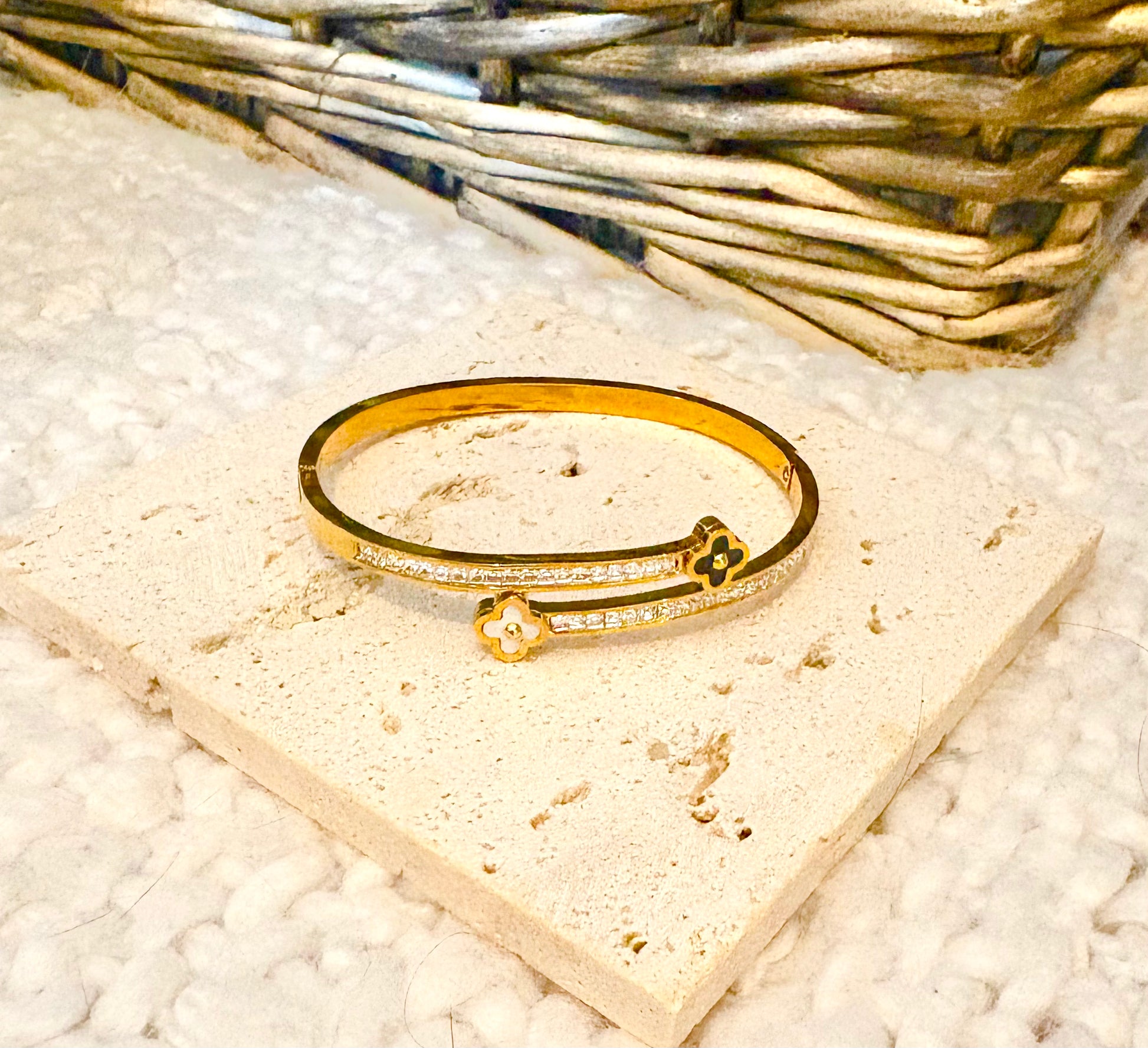 Gold bracelet with floral design on a textured surface