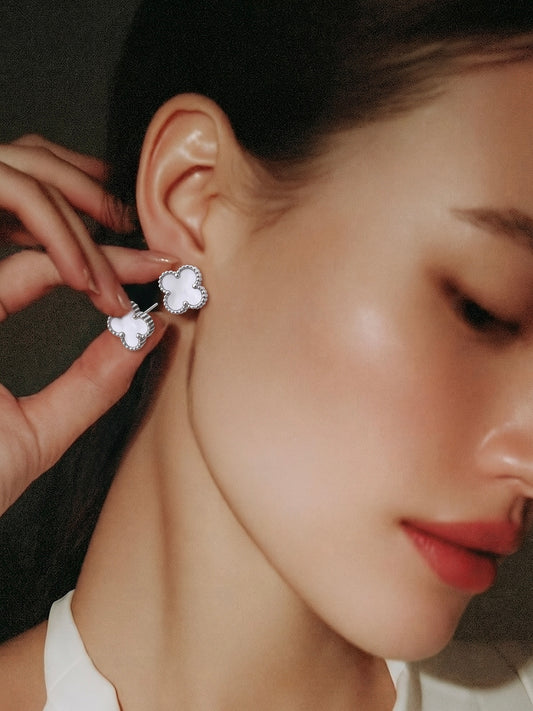 Close-up of a person wearing a floral earring with a blurred background