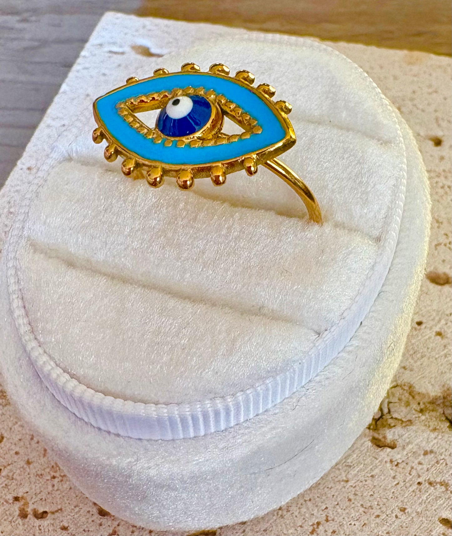 Gold ring with a blue and white evil eye design