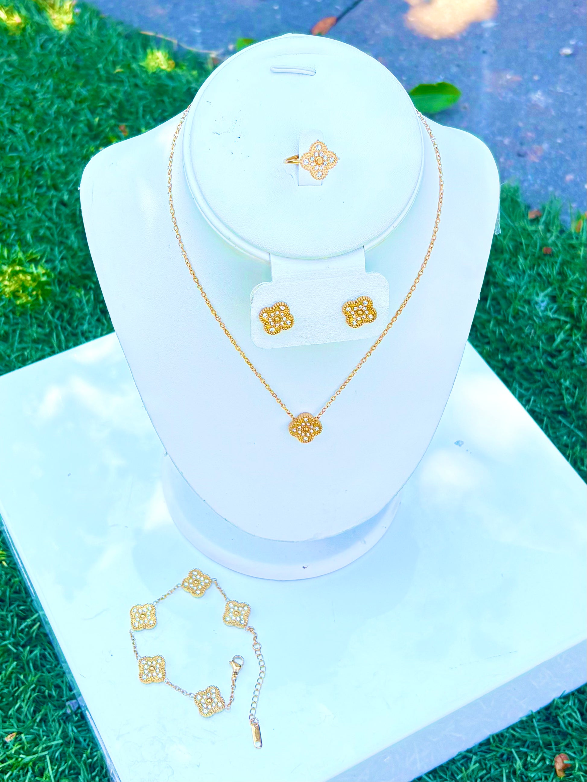 Gold jewelry set displayed on a white mannequin 
