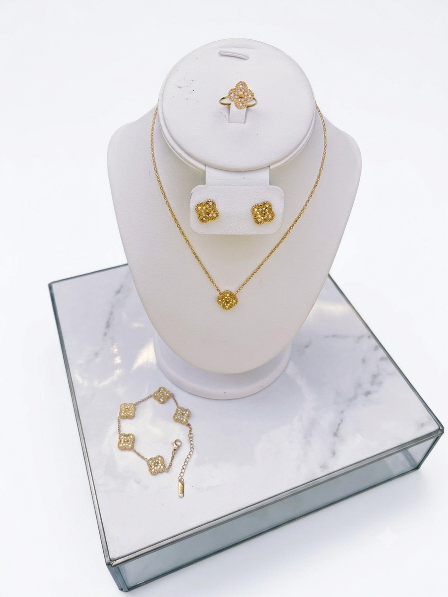 A gold jewelry set including a necklace, matching earrings, and bracelet.