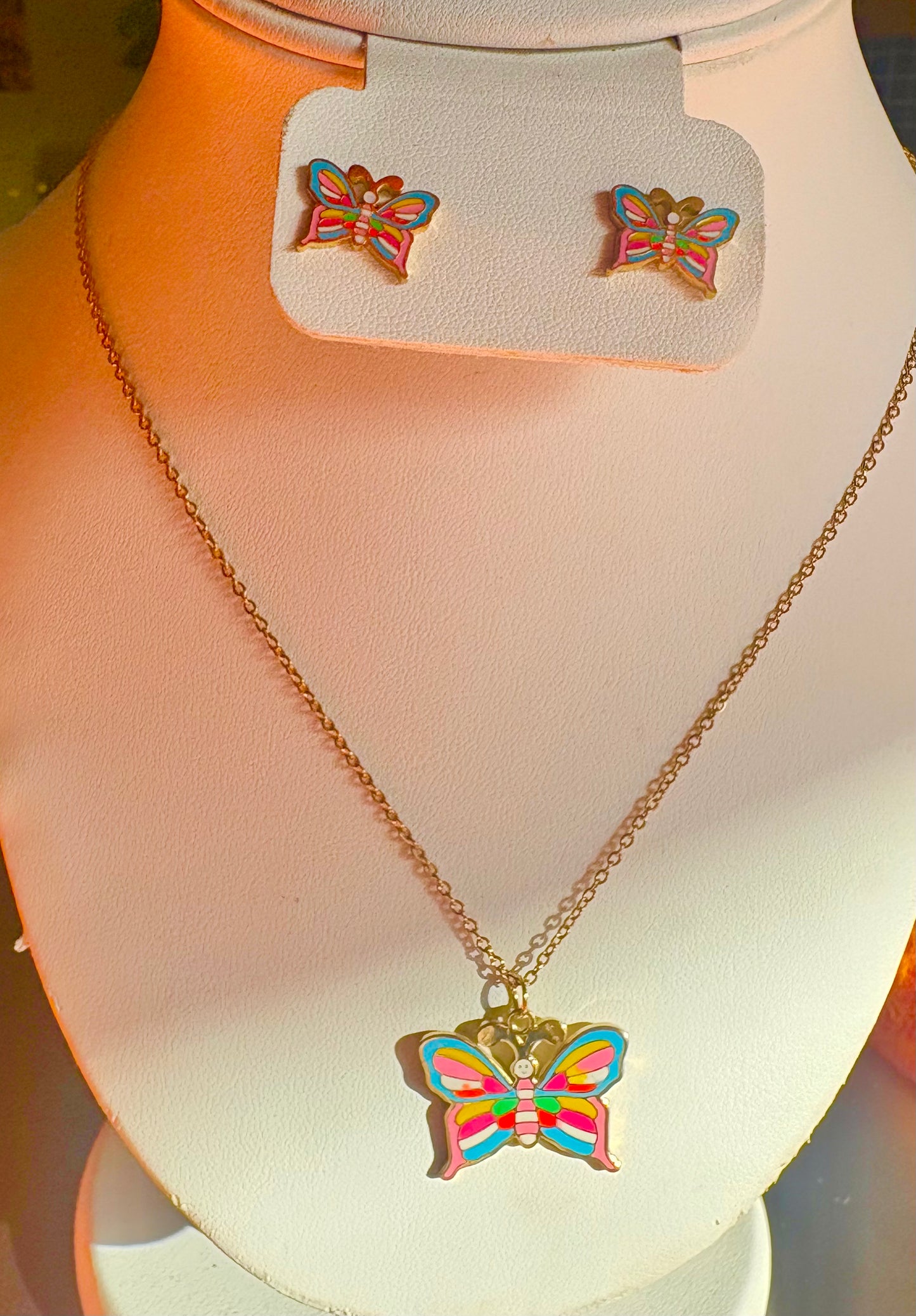 A gold-tone butterfly pendant necklace and matching butterfly stud earrings 