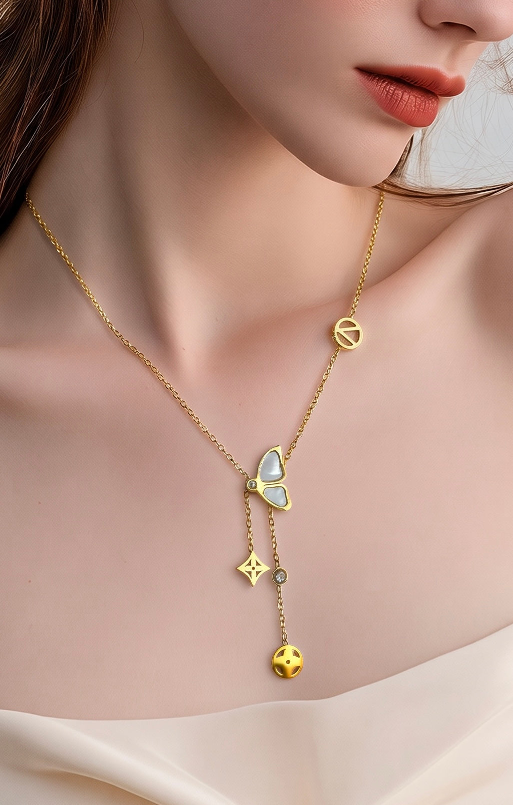  A delicate gold necklace with a butterfly pendant, a peace sign charm, and a dangling charm featuring a small gold sun.