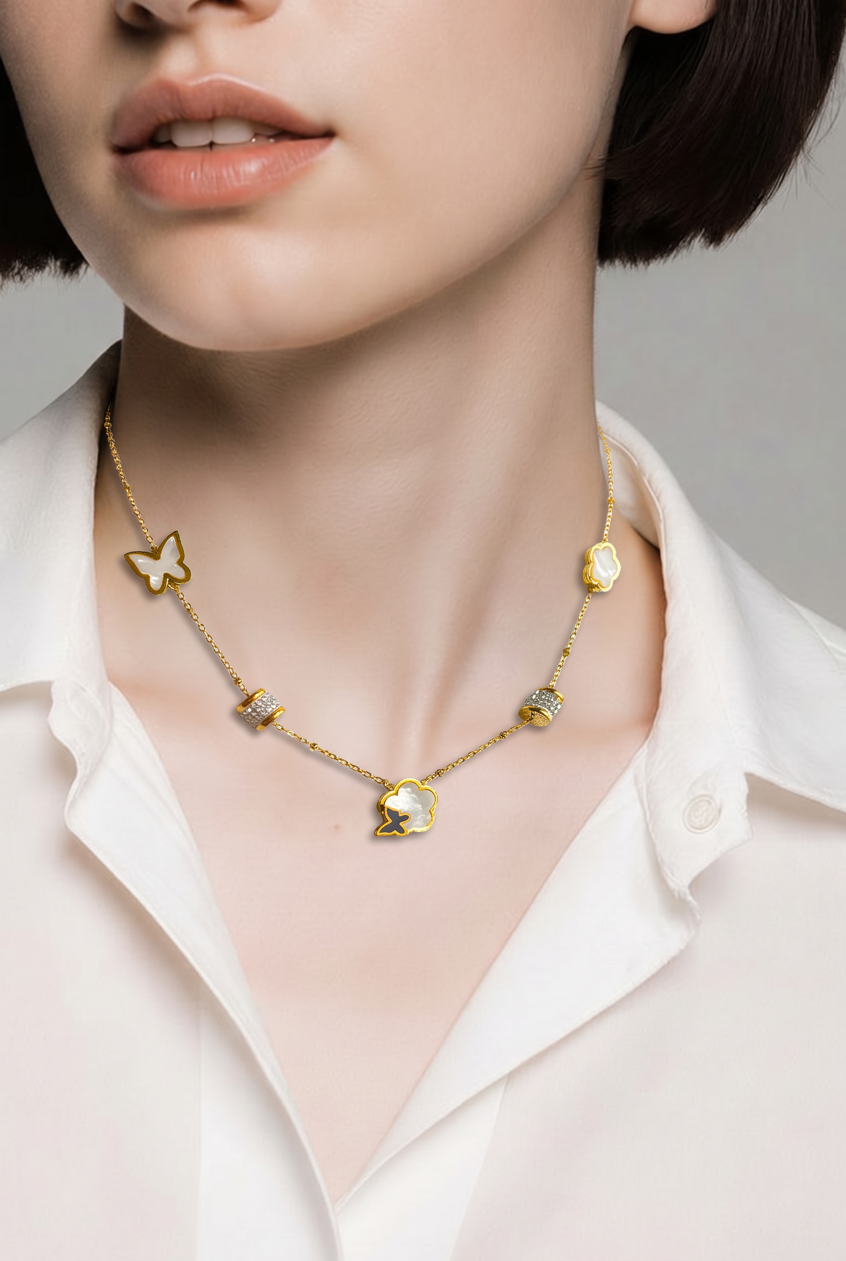 Gold necklace with a pendant worn by a person in a white shirt.