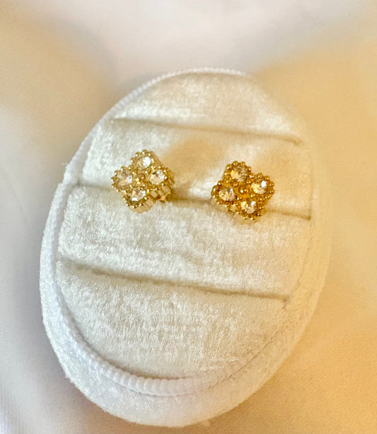 A pair of gold-toned stud earrings with clear gemstones