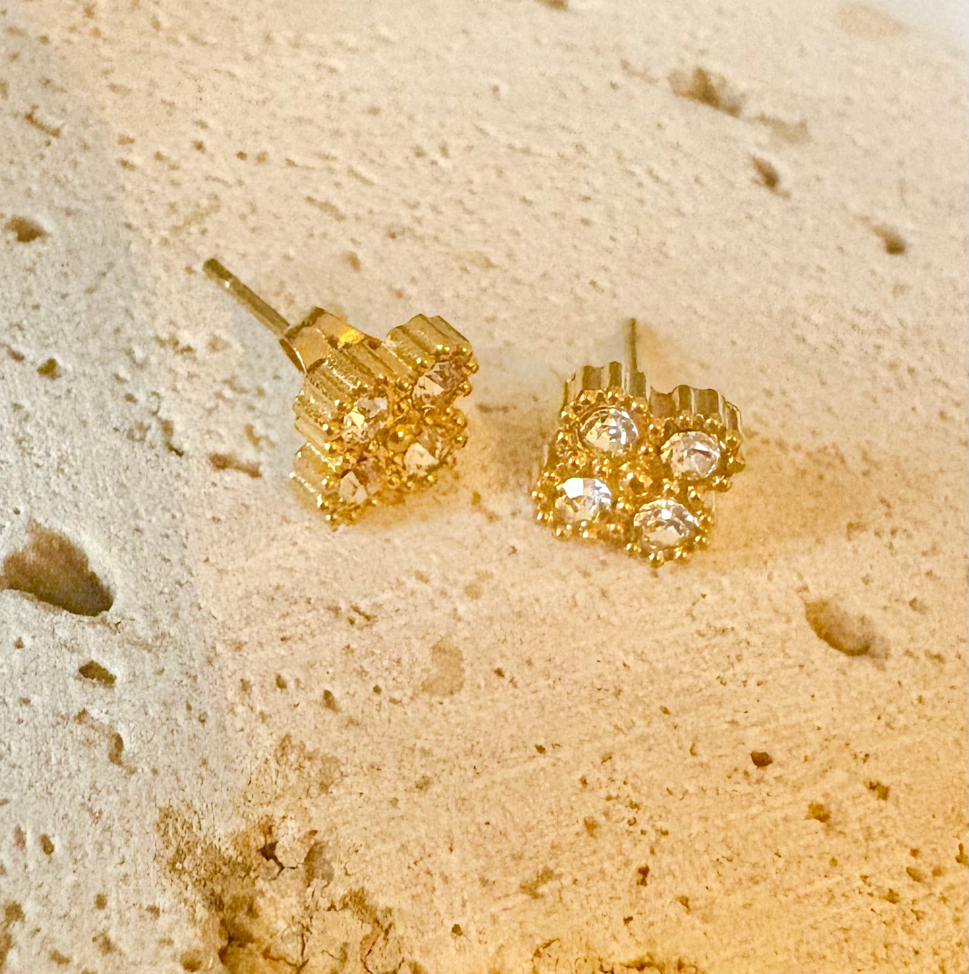 A pair of gold stud earrings with clear gemstones