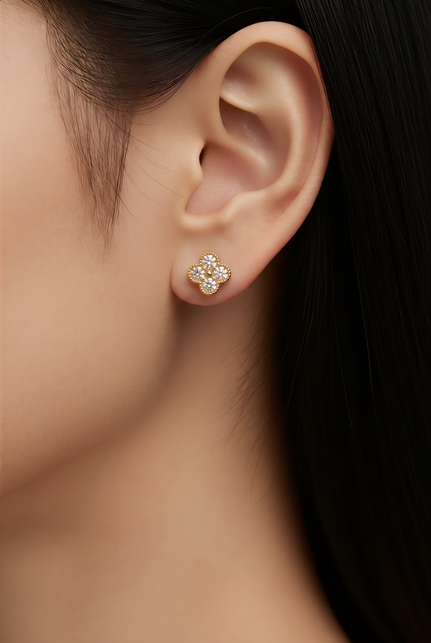 Close-up of an ear wearing a zircon gemstone stud earring 