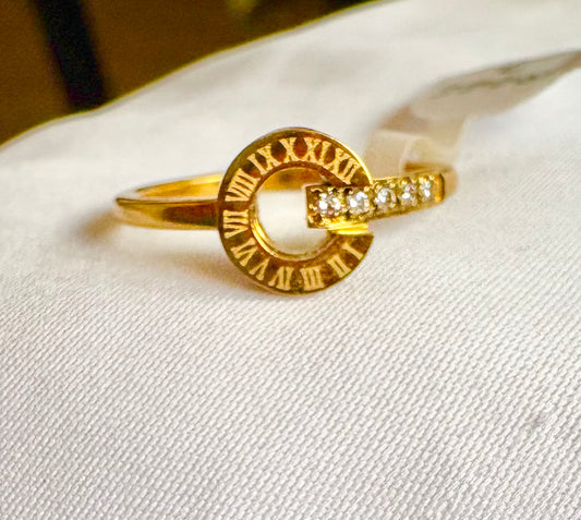 A gold ring with a circular open center engraved with Roman numerals 