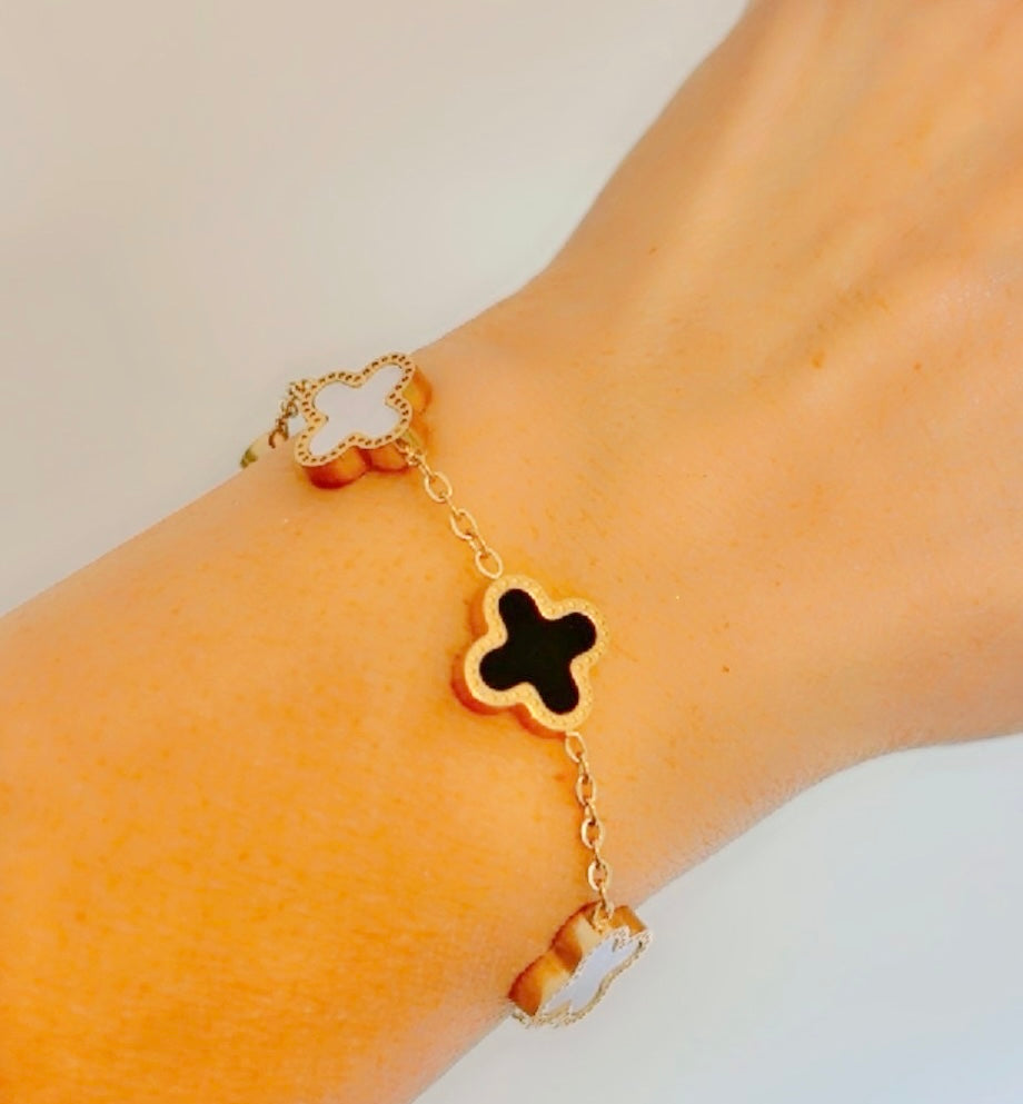 A gold-tone bracelet with B & W clover-shaped charms