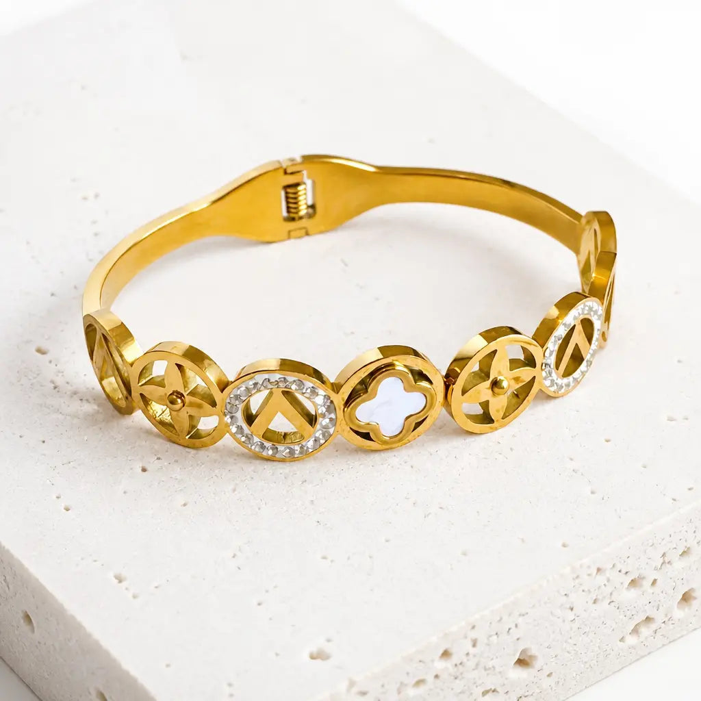 A gold-plated bangle bracelet featuring 8 circular links