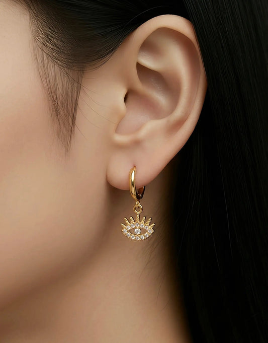 Gold huggie hoop earring with a dangling eye charm