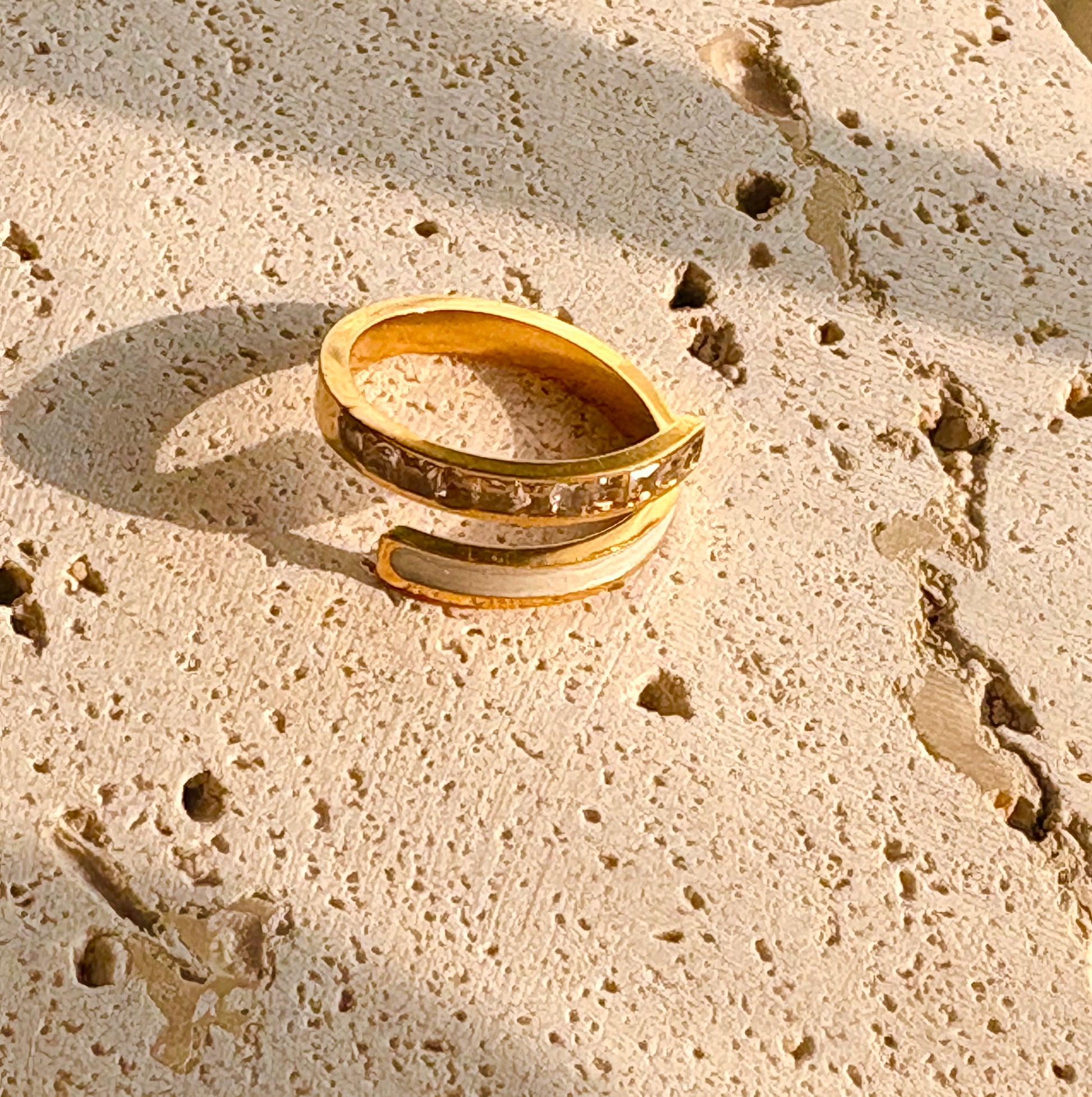 Gold ring on a textured beige surface