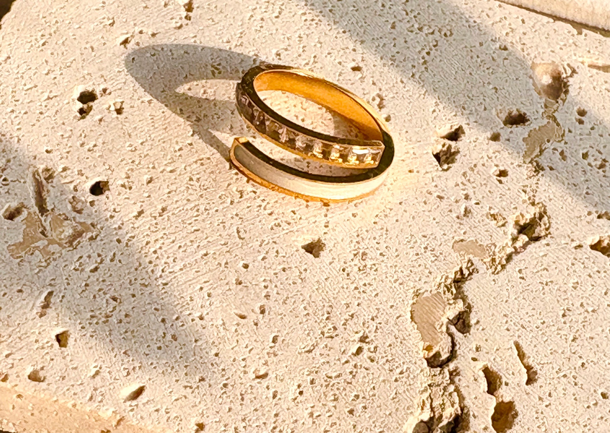 Gold ring on a textured beige surface