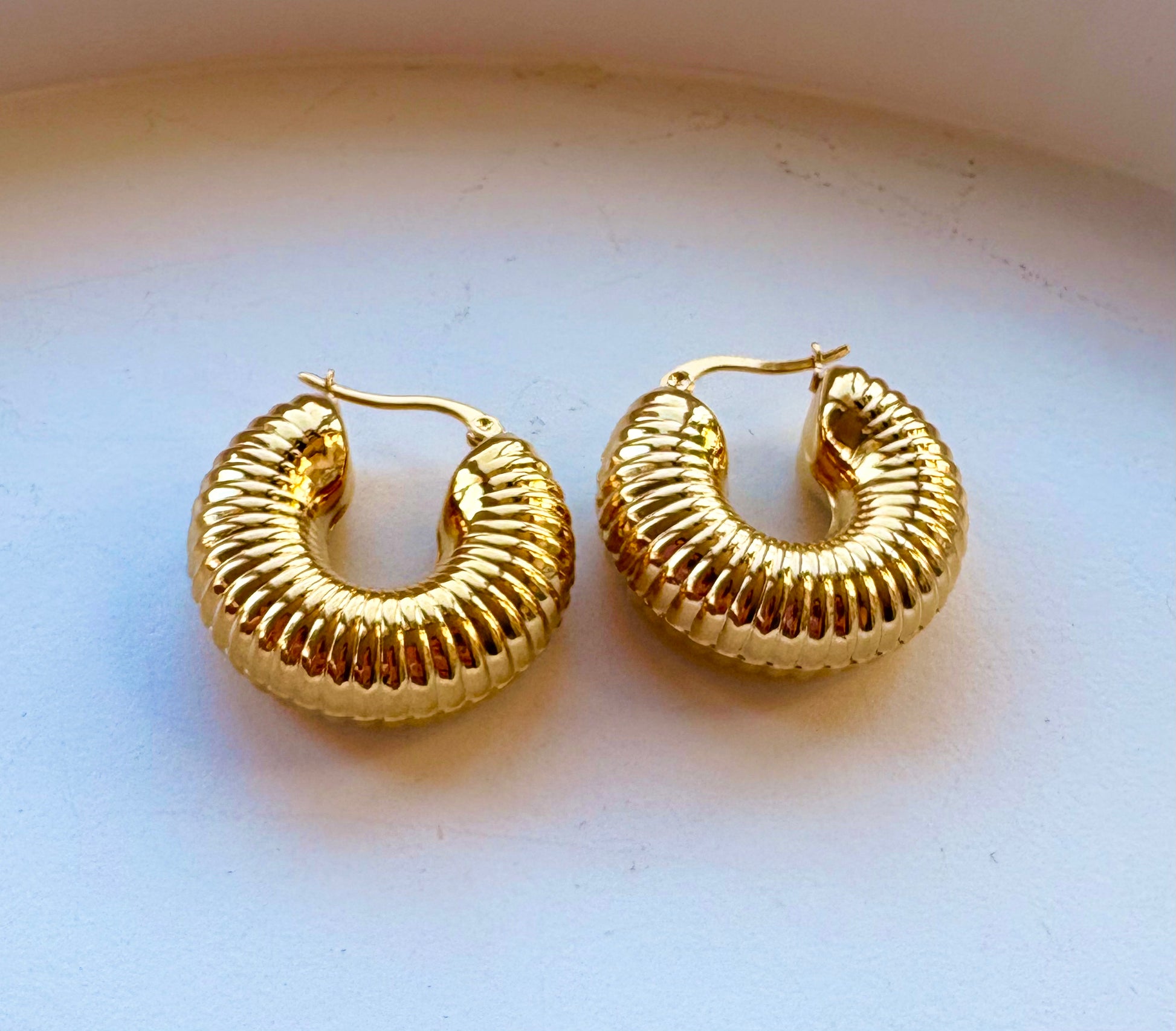 Pair of 18k gold‑plated ribbed hoop earrings showing thick ridged texture and shiny finish