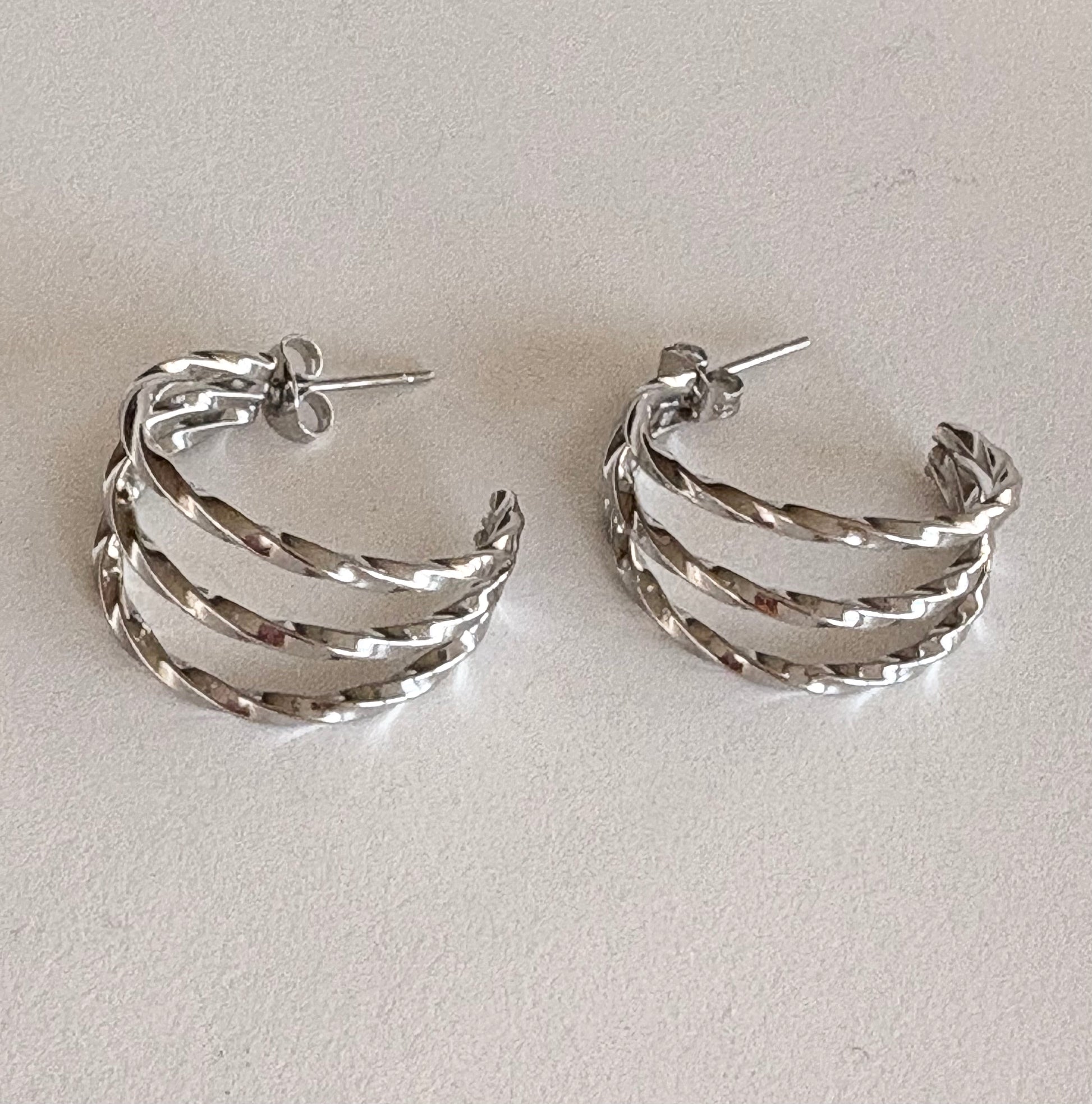 Gold and silver hammered triple hoop earrings laid flat, showing the layered design and 2 cm dimensions