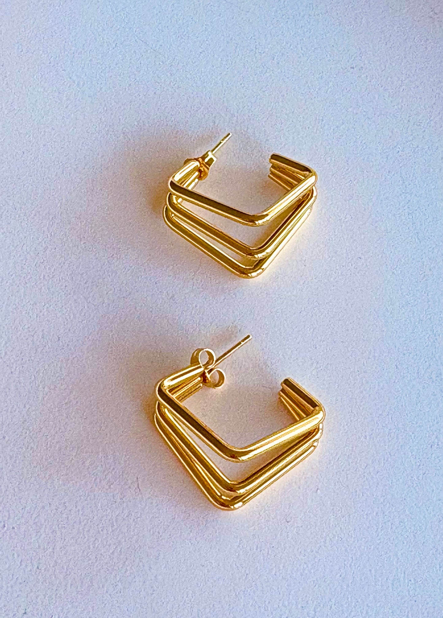 Close‑up of gold triple‑layer square hoop earrings showing their 2 cm size and polished finish.