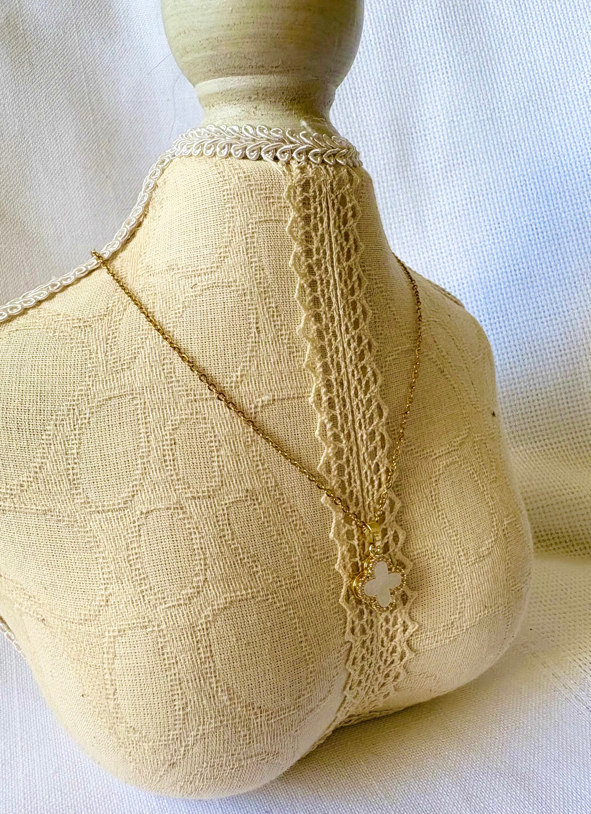 Mannequin wearing a beige textured garment with lace details on a white background