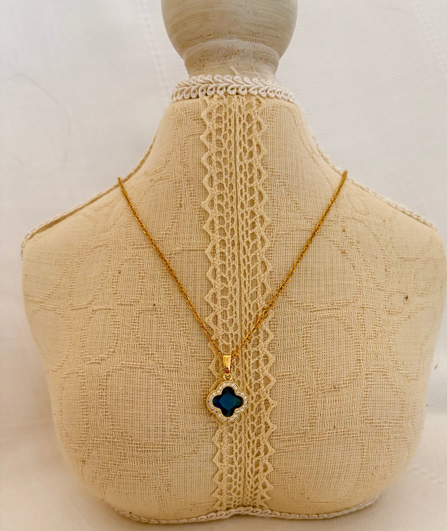 Necklace with a clover-shaped pendant on a mannequin bust.