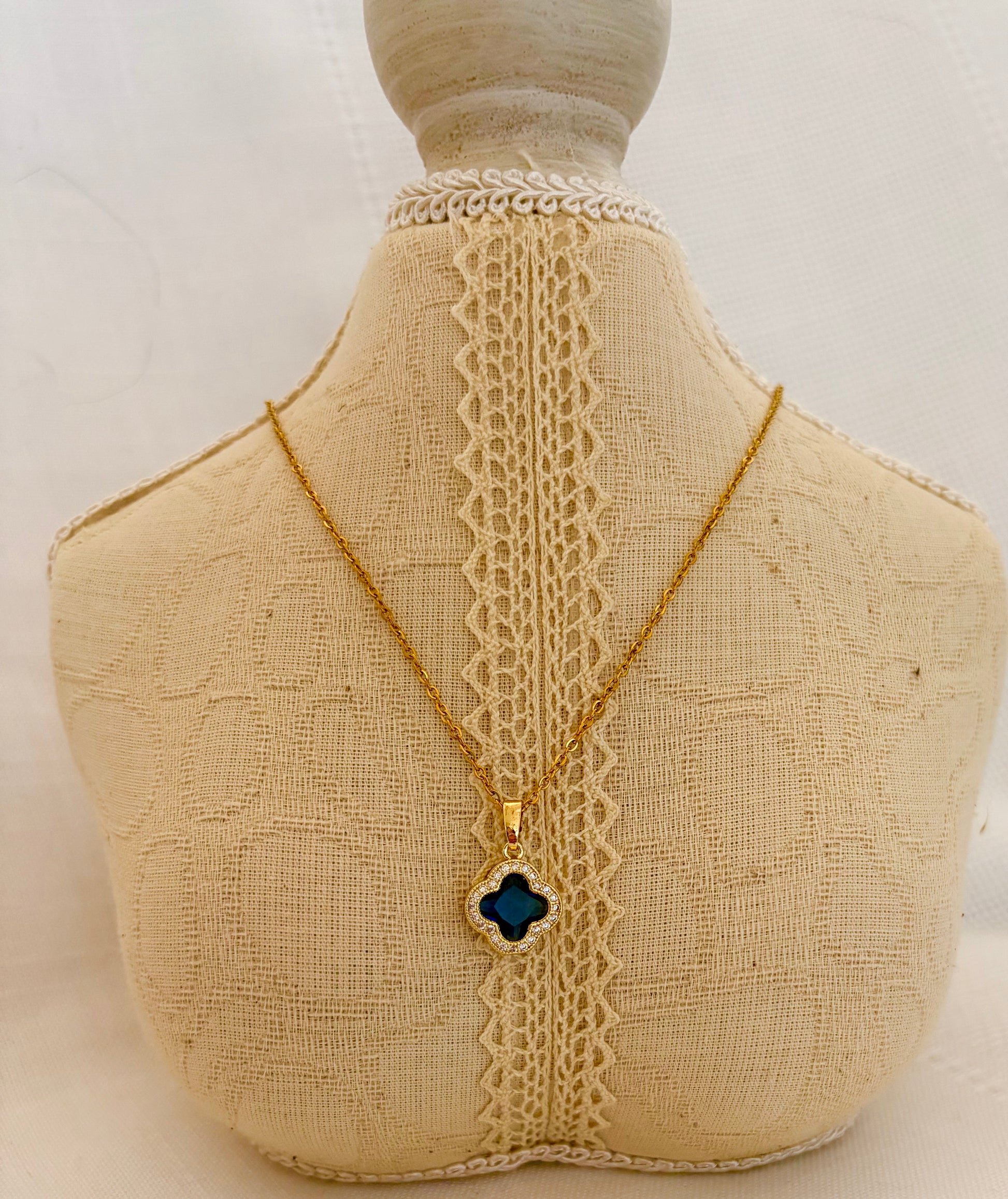 Necklace with a clover-shaped pendant on a mannequin bust.