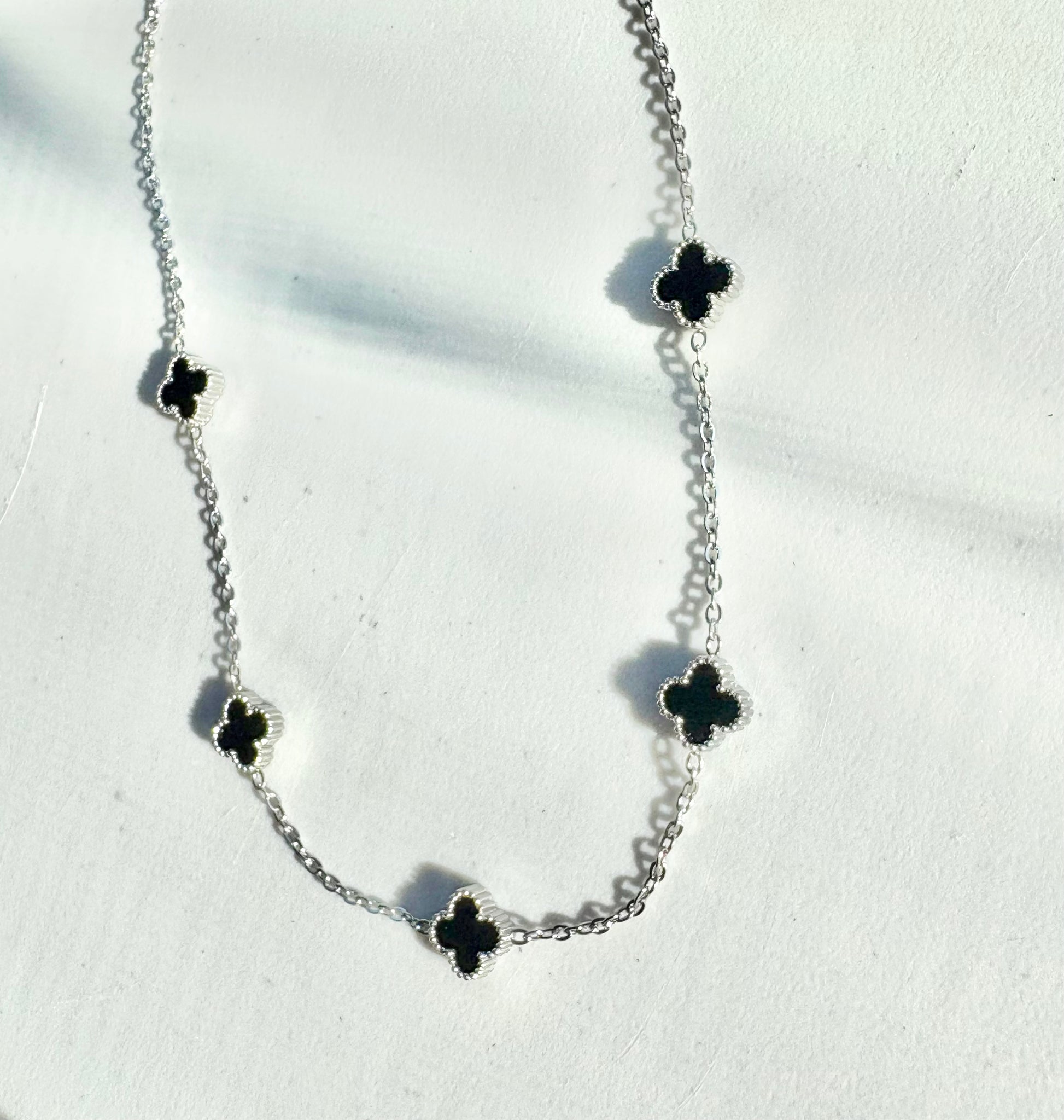 Silver 5-clover necklace with black clover charms on a stainless steel chain (42–46 cm)