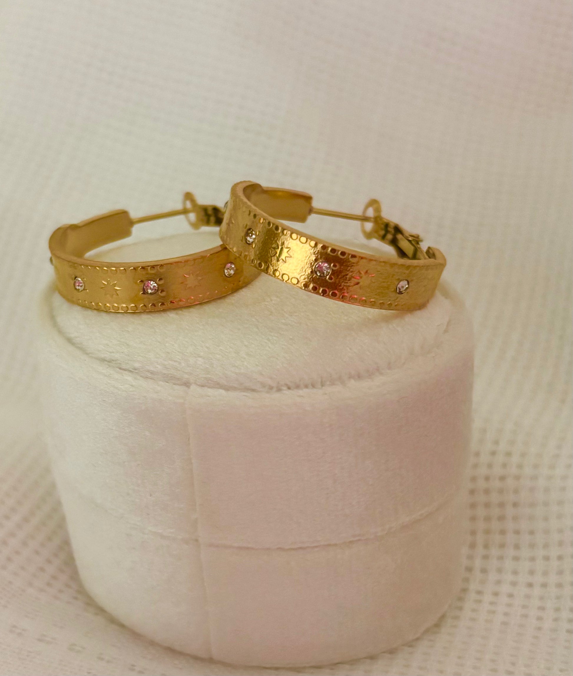 Pair of 3 cm gold hoop earrings featuring engraved starburst design and small crystal accents