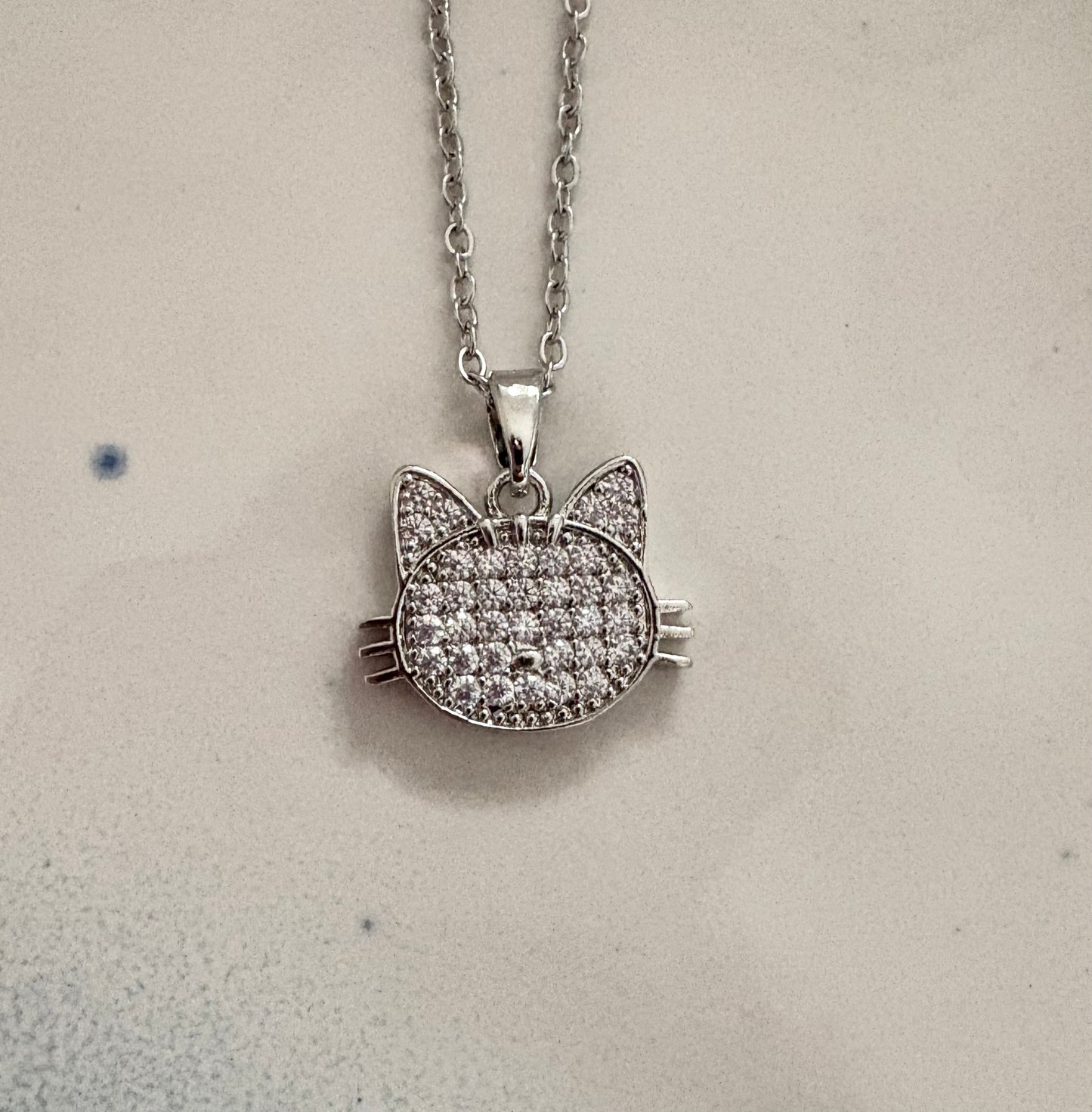 Silver cat face pendant necklace with pavé cubic zirconia stones.