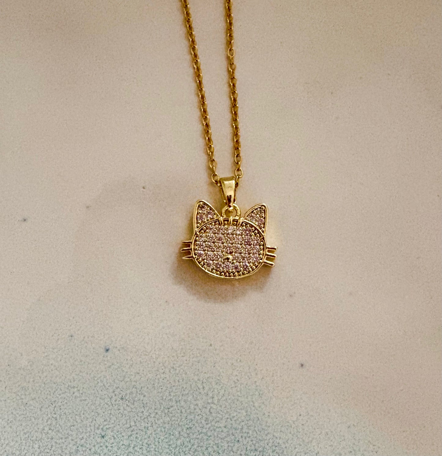 Gold cat face necklace featuring sparkly pavé stones on adjustable chain