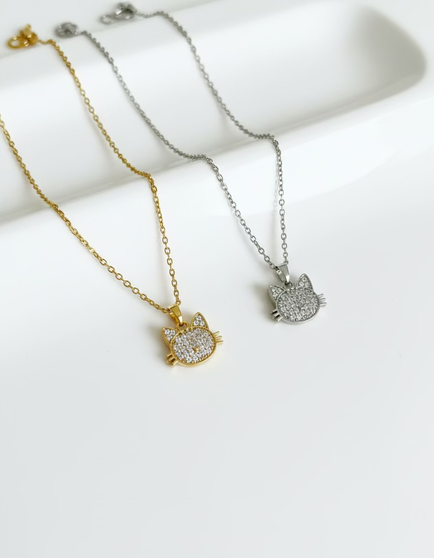 Close-up of pavé cat pendant in gold and silver finish.