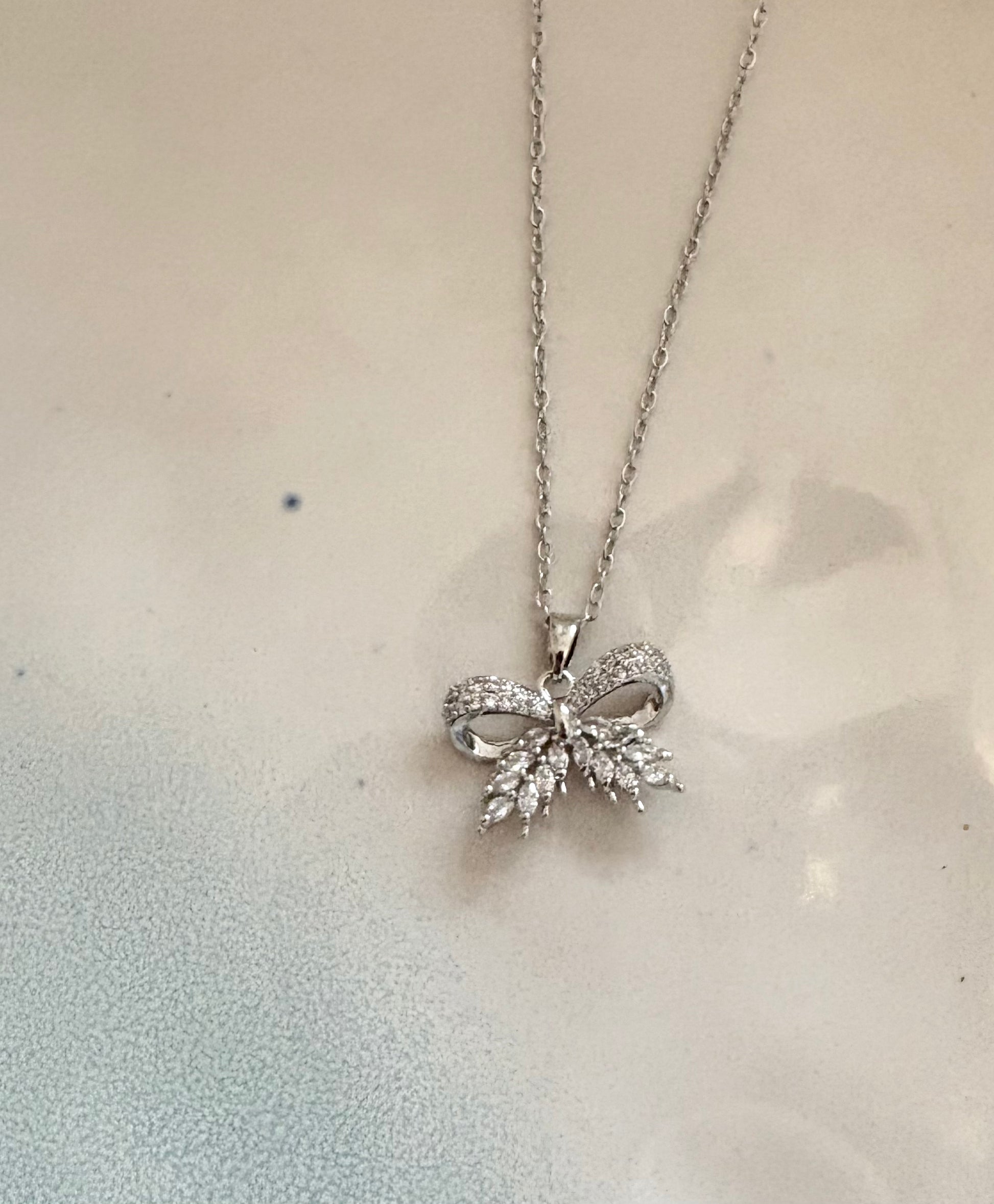 Gold bow pendant necklace with sparkling cubic zirconia stones