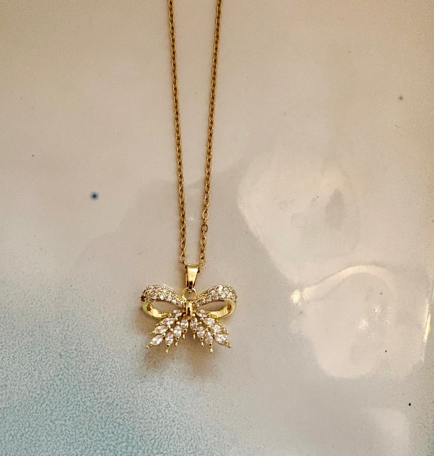 Gold bow pendant necklace with sparkling cubic zirconia stones