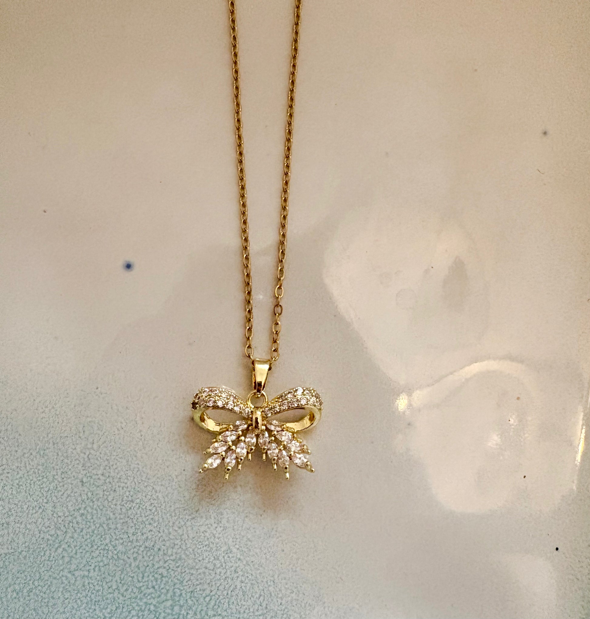 Gold bow pendant necklace with sparkling cubic zirconia stones